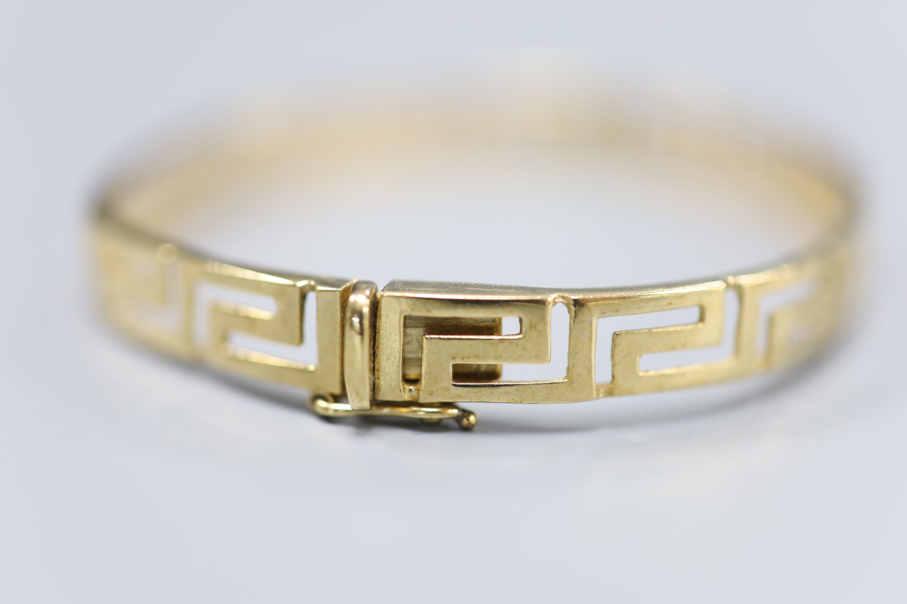 A 9ct gold Greek key design hinged bangle, 10g.